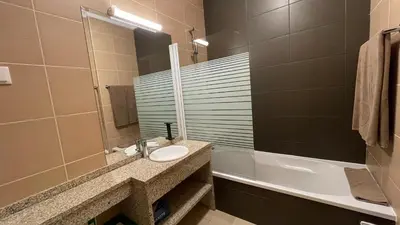 a bathroom with a sink and a mirror and a tub at Oura Oasis A by Check-in Portugal in Albufeira