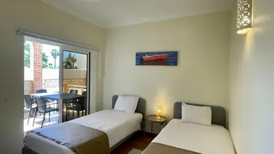 two beds in a room with a table and a window at Oura Oasis B by Check-in Portugal in Albufeira