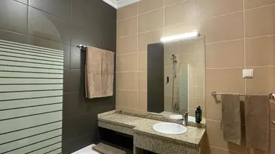 a bathroom with a sink and a shower with a mirror at Oura Oasis B by Check-in Portugal in Albufeira