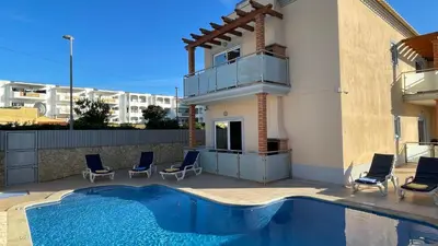 a house with a swimming pool next to a building at Oura Oasis C by Check-in Portugal in Albufeira