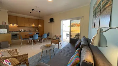 a living room and kitchen with a couch and a table at Oura Oasis C by Check-in Portugal in Albufeira