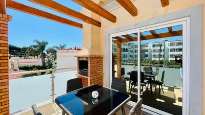 a balcony with a fireplace and a table and chairs at Oura Oasis D by Check-in Portugal in Albufeira