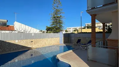 a swimming pool with two chairs next to a house at Oura Oasis D by Check-in Portugal in Albufeira