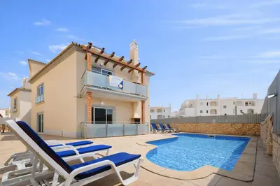 a villa with a swimming pool and lounge chairs at Oura Oasis F by Check-in Portugal in Albufeira