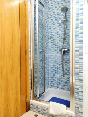 a blue tiled bathroom with a shower with a window at Sao Rafael Beach Luxury Home by Be Cherish in Albufeira