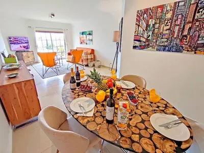 a dining room table with wine bottles and fruit on it at Sao Rafael Beach Luxury Home by Be Cherish in Albufeira