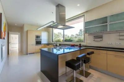 a large kitchen with a large island with a sink at Villa Atlantic Pearl - Luxury villa located in in Quinta do Lago