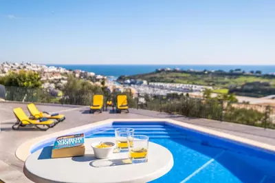 a pool with a table with drinks and a view of the ocean at Villa Blue Lagoon by Algarve Vacation in Albufeira
