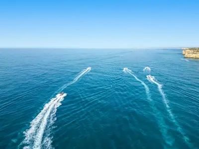 two boats in the water next to a large cliff at Villa Blue Lagoon by Algarve Vacation in Albufeira