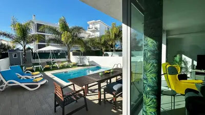 a patio with a table and chairs next to a swimming pool at Moon by Check-in Portugal in Albufeira
