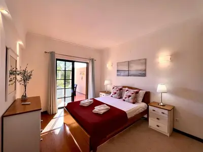 a bedroom with a large bed and a balcony at Vilamoura Paradise Golf With Pool by Homing in Vilamoura