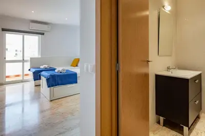 a bathroom with a bed and a sink in a room at Duas Palmeiras by LovelyStay in Albufeira