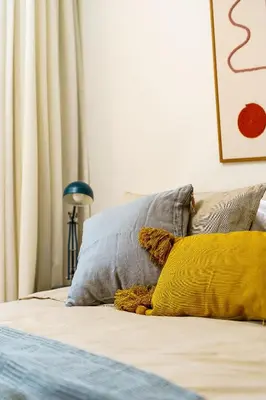 a bed with two pillows and a yellow pillow at Estúdio do Largo - Vilamoura in Vilamoura