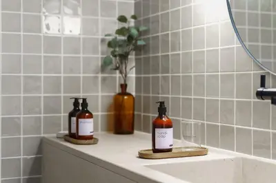 a bathroom sink with two bottles of alcohol on it at Estúdio do Largo - Vilamoura in Vilamoura