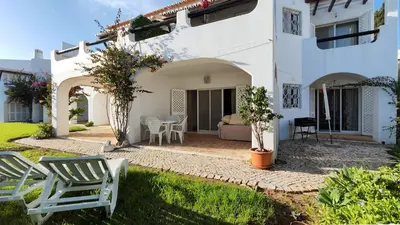 a white house with chairs and a patio at Sao Rafel Beach house in Albufeira