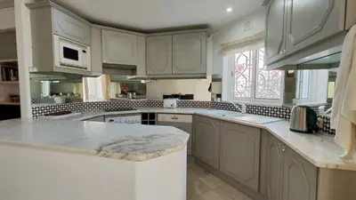a kitchen with white cabinets and a counter top at Sao Rafel Beach house in Albufeira