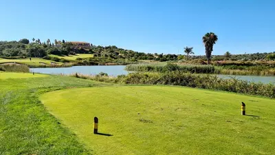 a golf course with a view of a river and a green at Sao Rafel Beach house in Albufeira