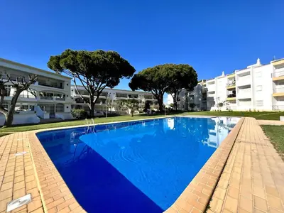 a large blue swimming pool in front of a building at Vilamoura Garden View 1 With Pool by Homing in Vilamoura