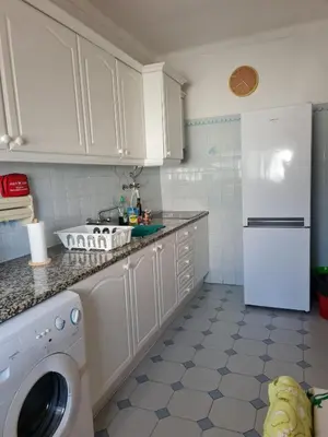 a kitchen with white cabinets and a white refrigerator at Timi's House - Espaçoso apartamento a 350 m da praia e centro da cidade velha in Albufeira