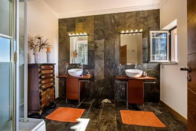 a bathroom with two sinks and two mirrors at Villa Mauri Luxe - Beautiful beachfront villa in Albufeira
