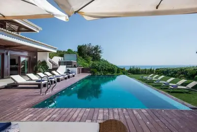 an image of a swimming pool with chairs and an umbrella at Villa Plage Grande - Superstar luxury - Beachtop in Olhos de Água