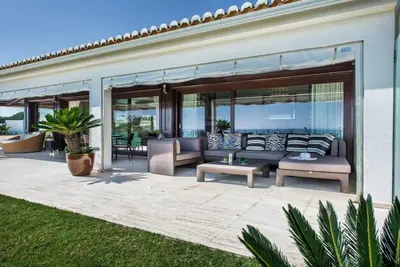 a patio with a couch and chairs on it at Villa Plage Grande - Superstar luxury - Beachtop in Olhos de Água