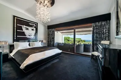 a bedroom with a large bed and a large window at Villa Plage Grande - Superstar luxury - Beachtop in Olhos de Água