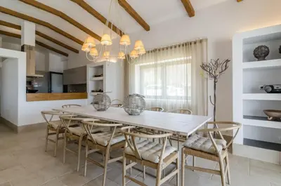 a dining room with a white table and chairs at Villa Colom in Quarteira