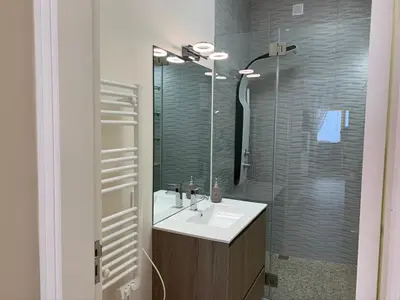 a bathroom with a sink and a shower with a mirror at Eine Wohnung für den perfekten Urlaub !!! in Quarteira