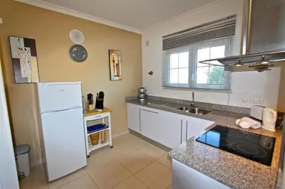 a kitchen with a white refrigerator and a sink at Spacious Vilamoura Villa 4 Bedrooms Villa Amendoeira Table Tennis in Quarteira