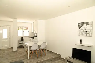 a living room with a table and chairs and a tv at O Pinhal do Avô - BY BEDZY in Almancil