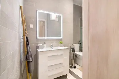 a bathroom with a sink and a mirror and a toilet at Casa na Travessa in Faro
