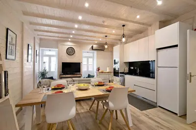 a living room with a couch and a kitchen at Casa na Travessa in Faro