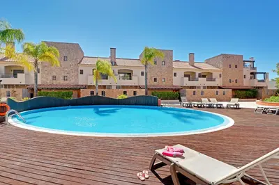 a swimming pool on a deck with a chair and a lounger at Victoria Secret in Vilamoura