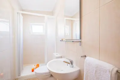 a white bathroom with a sink and a toilet at Casa Negril by Algarve Vacation in Albufeira