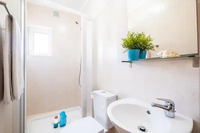 a bathroom with a sink and a toilet and a shower at Casa Negril by Algarve Vacation in Albufeira