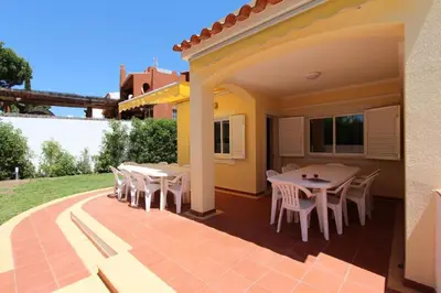 a patio with white tables and chairs on a house at Modern Vilamoura Villa Close To Pinhal Golf Villa Maelou 4 Bedrooms in Quarteira