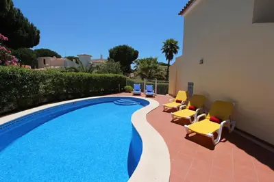 a swimming pool with lounge chairs next to a building at Modern Vilamoura Villa Close To Pinhal Golf Villa Maelou 4 Bedrooms in Quarteira