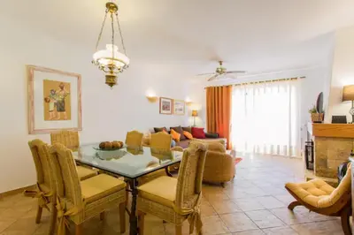 a living room with a table and chairs and a couch at Beach House (Golf) - Falésia/Albufeira in Albufeira