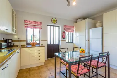 a kitchen with a glass table and chairs in it at Beach House (Golf) - Falésia/Albufeira in Albufeira