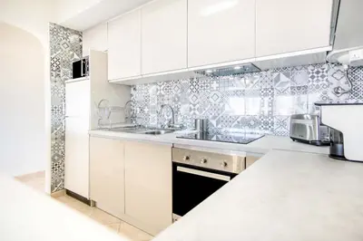a white kitchen with white cabinets and a sink at Albufeira Holidays Near The Strip in Albufeira
