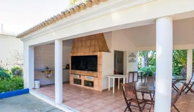 a patio with a fireplace and a table and chairs at Flamingos Apartment with 2 swimming pool com check in e check out ao domingo em julho e agosto in Albufeira