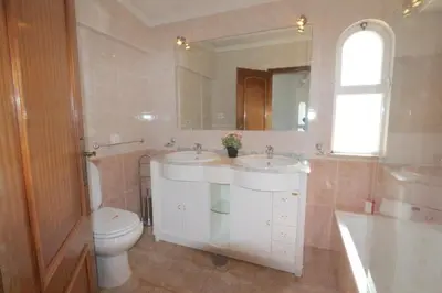 a bathroom with two sinks and a toilet and a mirror at Traditional Portuguese Villa 5 Bedrooms Villa Girassol Prime Location in Quarteira