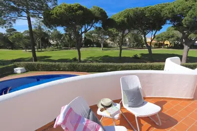 a couple of chairs sitting next to a swimming pool at Traditional Portuguese Villa 5 Bedrooms Villa Girassol Prime Location in Quarteira