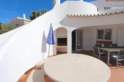a patio with a table and a blue umbrella at Traditional Portuguese Villa 5 Bedrooms Villa Girassol Prime Location in Quarteira