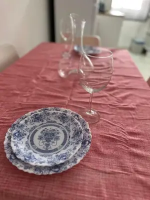 a table with a plate and two wine glasses at Alojamento Ramos in Quarteira