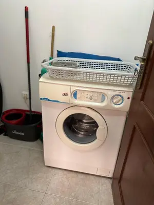 a washing machine with a basket on top of it at Alojamento Ramos in Quarteira