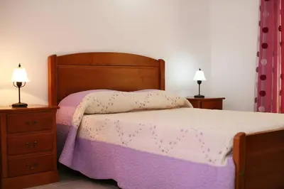 a bedroom with a bed and two night stands and two lamps at Villa Da Duarte - walkable to beach shops bars in Albufeira