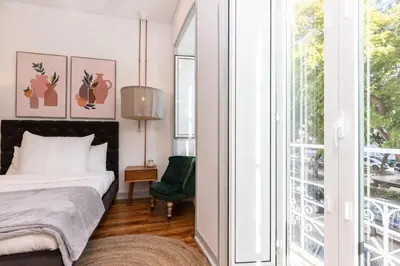 a bedroom with a bed and a green chair at @ rita'splace in Faro