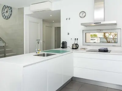 a white kitchen with a sink and a clock at Harmony 4B House by Stay ici Algarve Holiday Rental in Albufeira